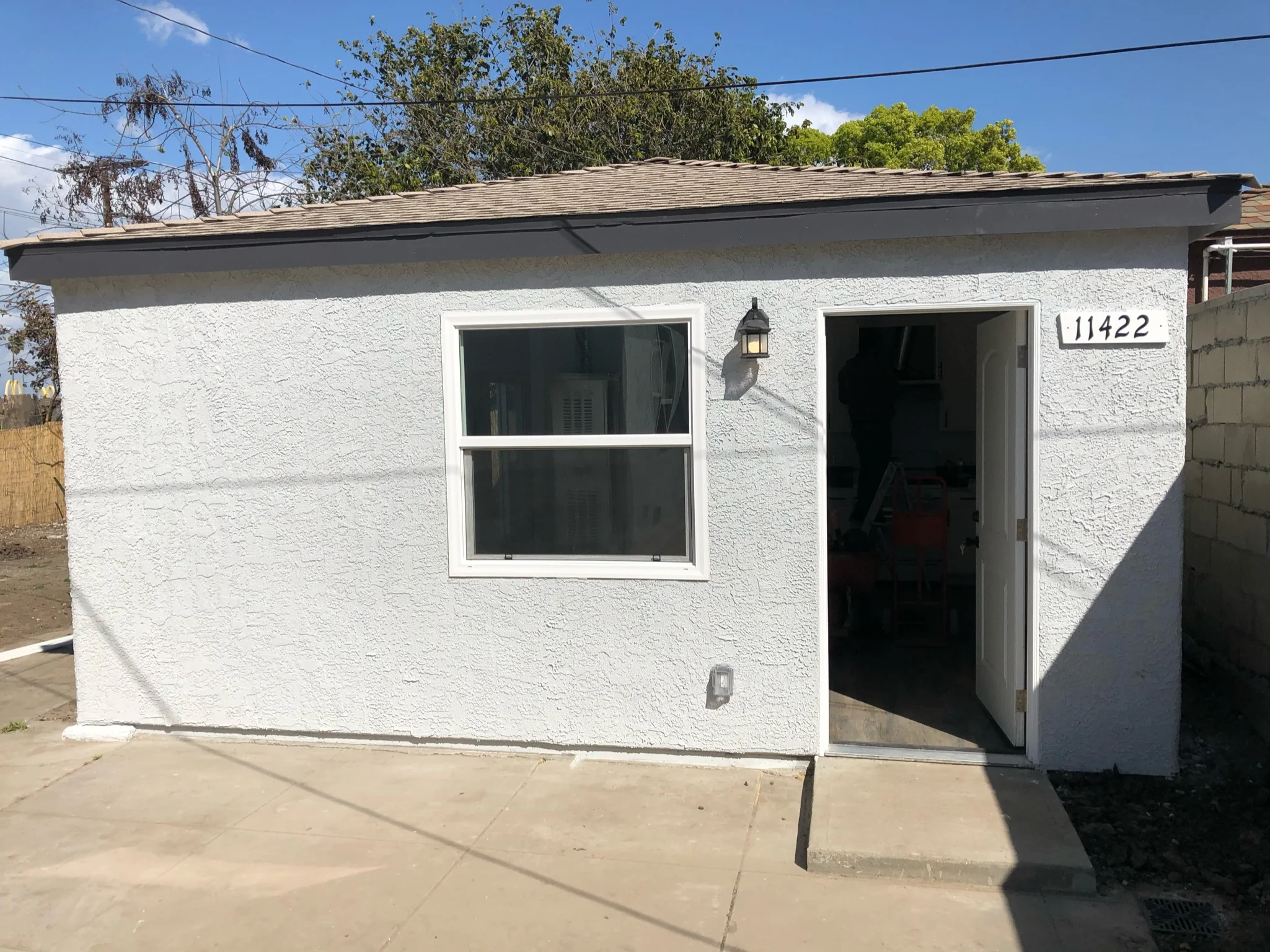 White stucco house with new window, door, and roof renovation in Riverside