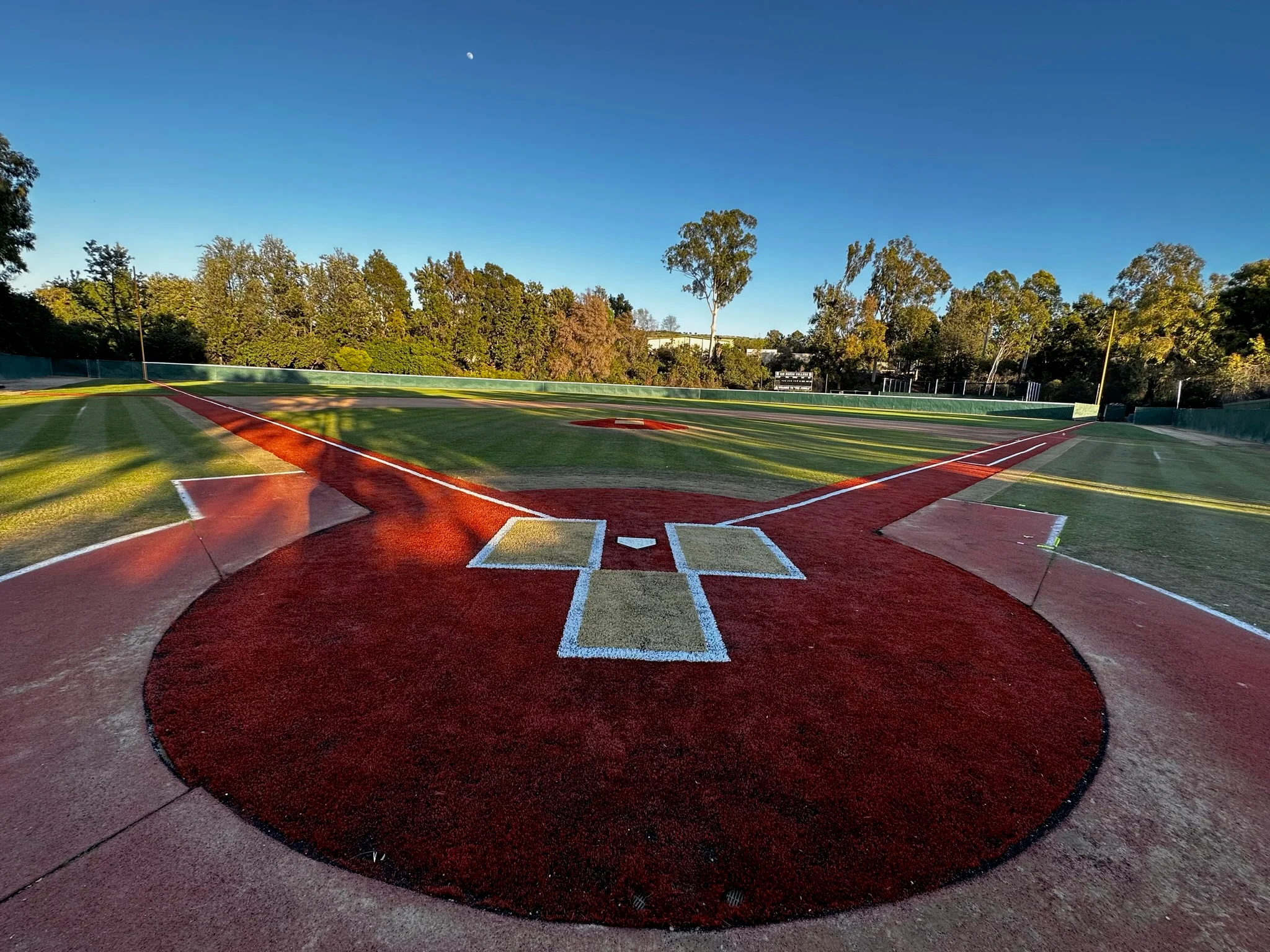 Aerial view of completed baseball field with red infield, green outfield, and white markings