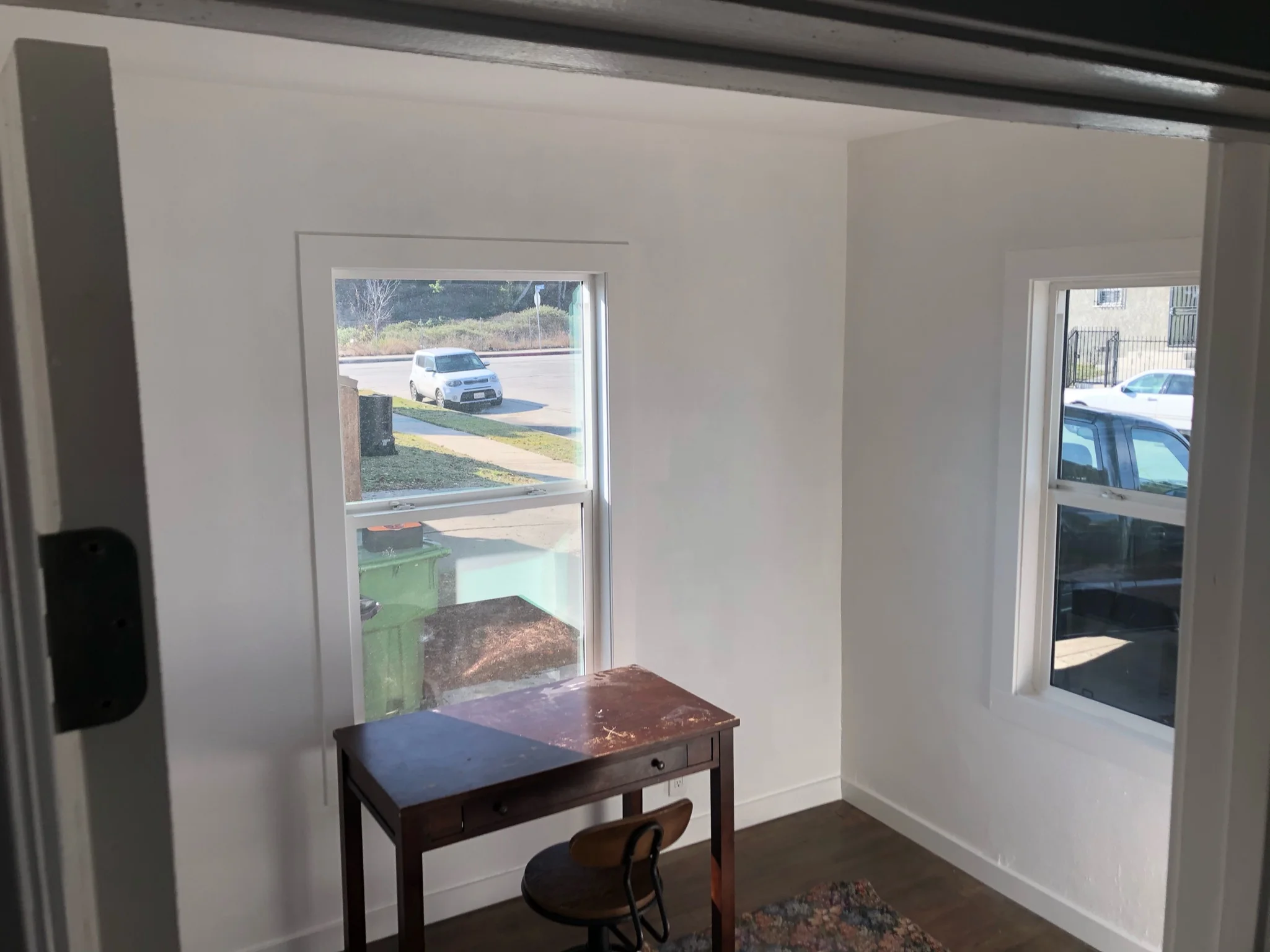 Interior room with white drywall walls and two glass sliding doors overlooking parking lot