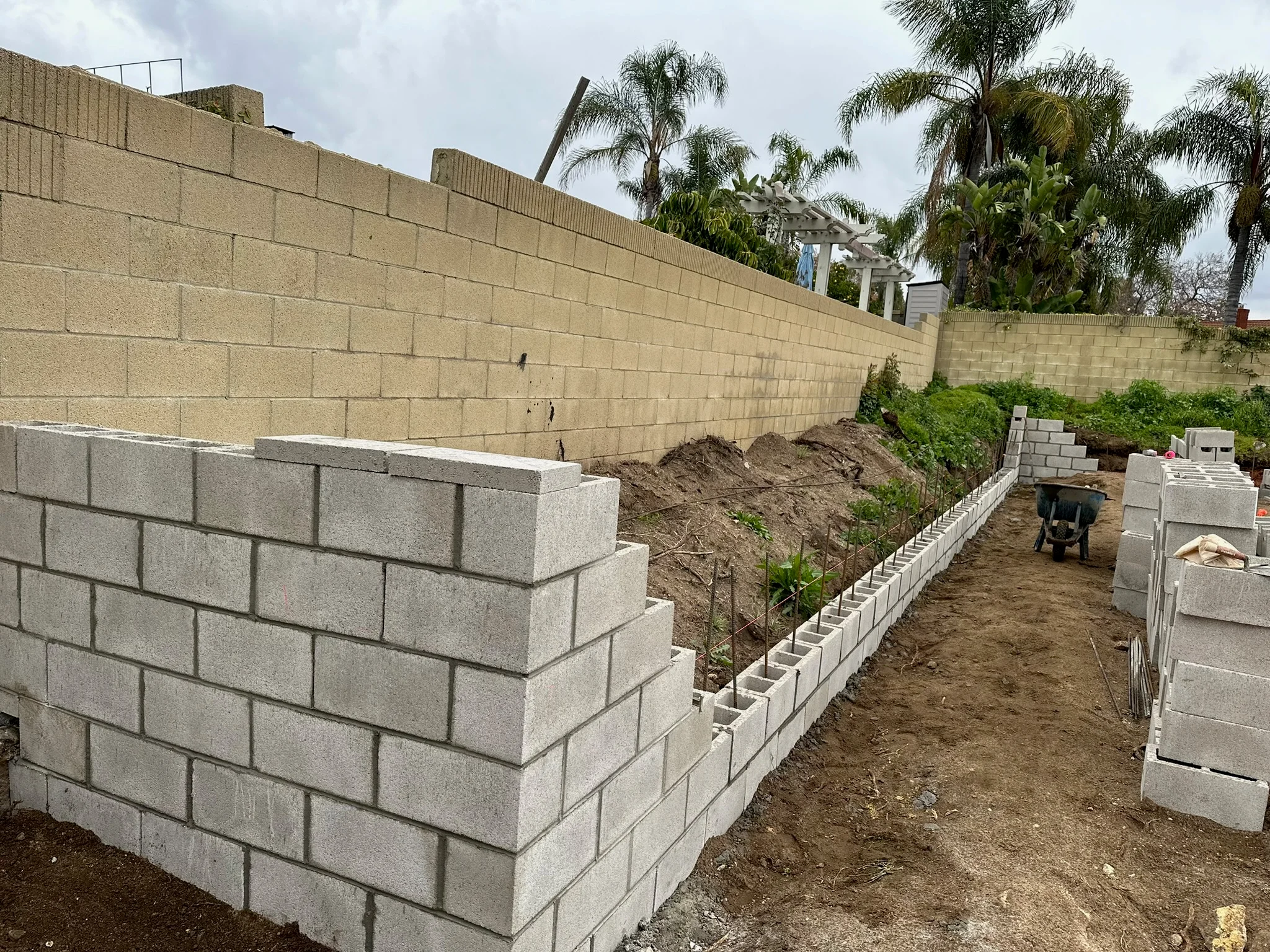 Concrete block retaining wall with tiered construction on sloped residential lot