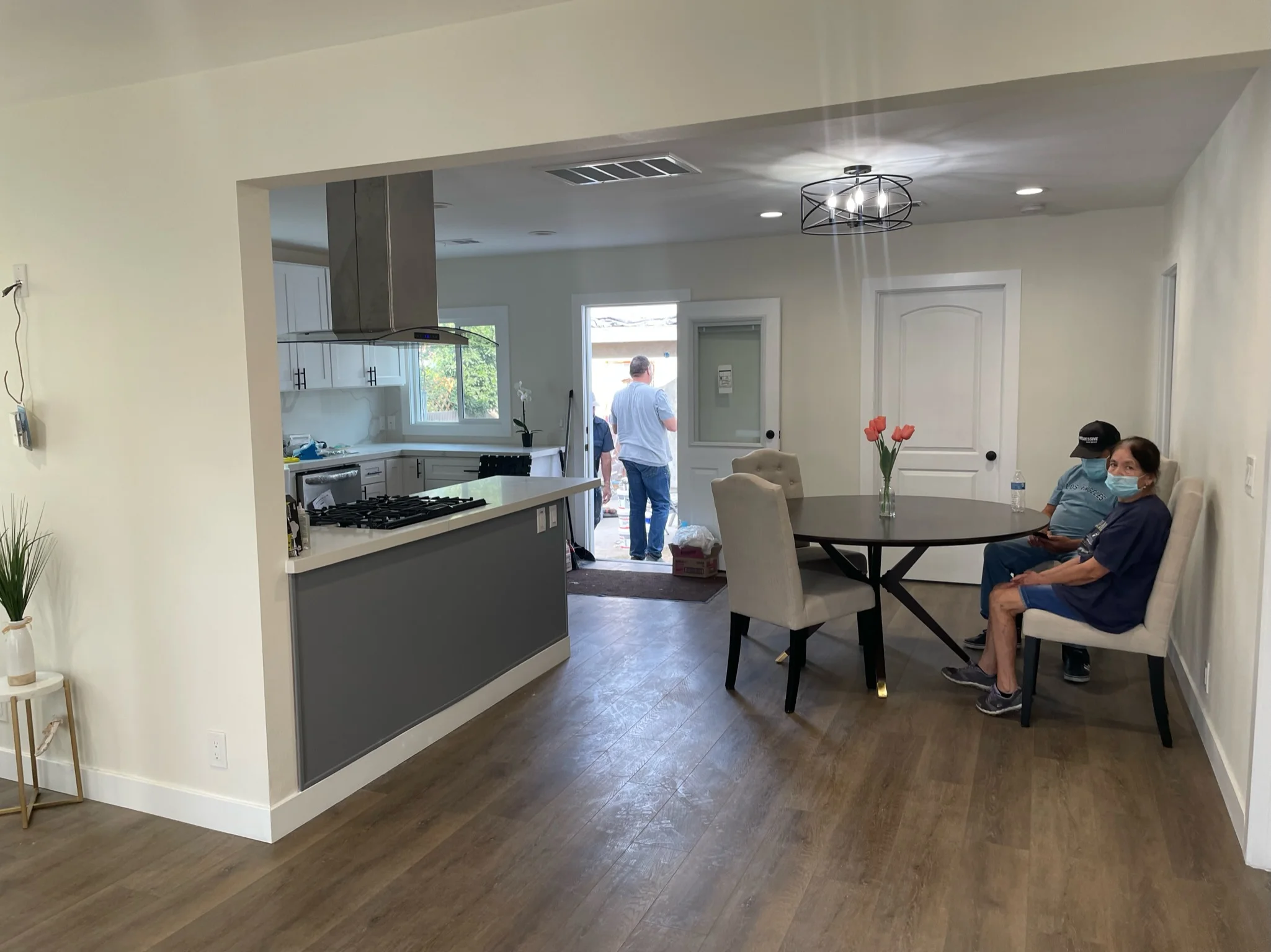 Modern kitchen with gray cabinetry and dining area with dark wood flooring