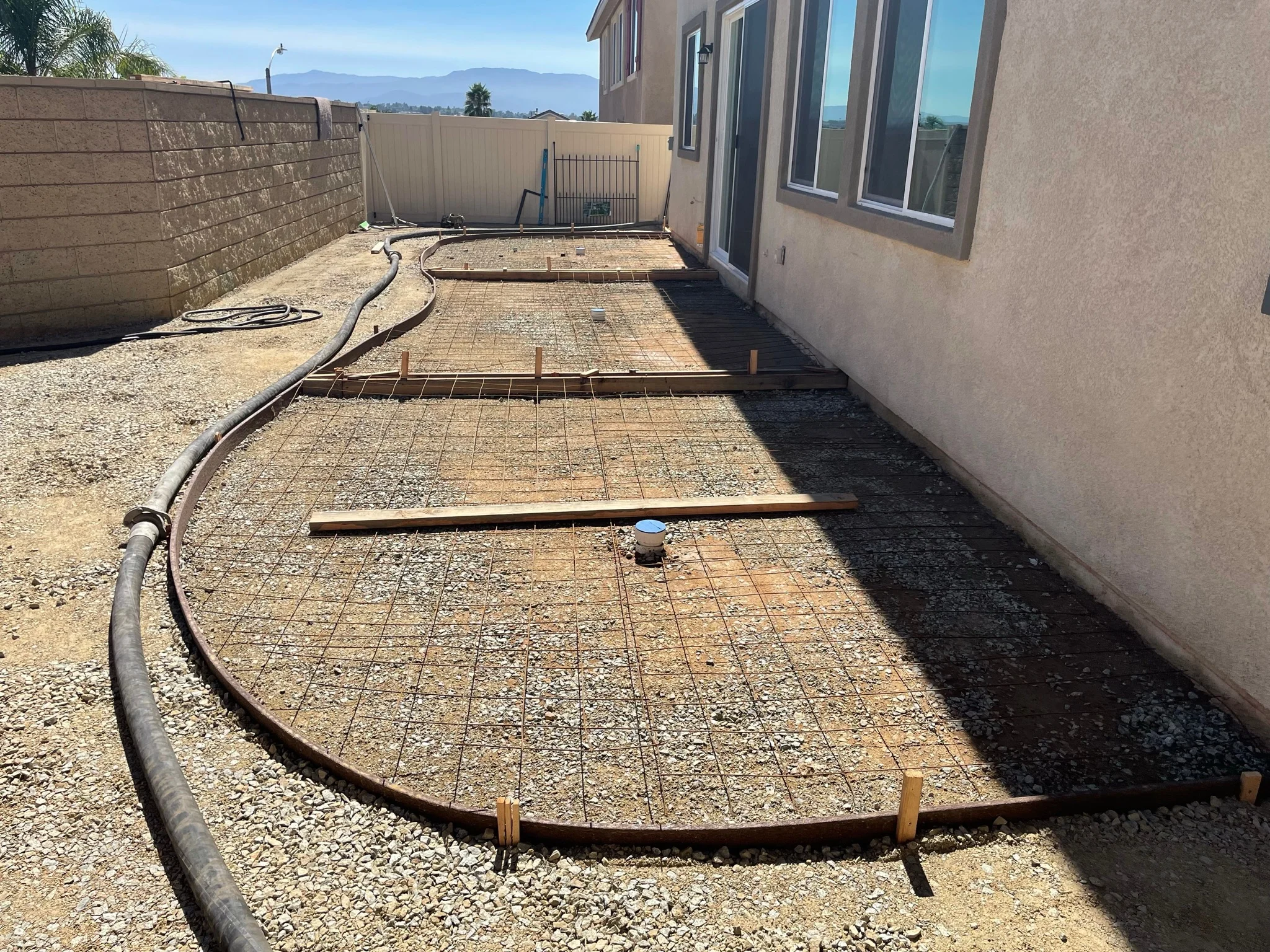 Backyard concrete patio foundation with rebar grid and wooden forms ready for pour
