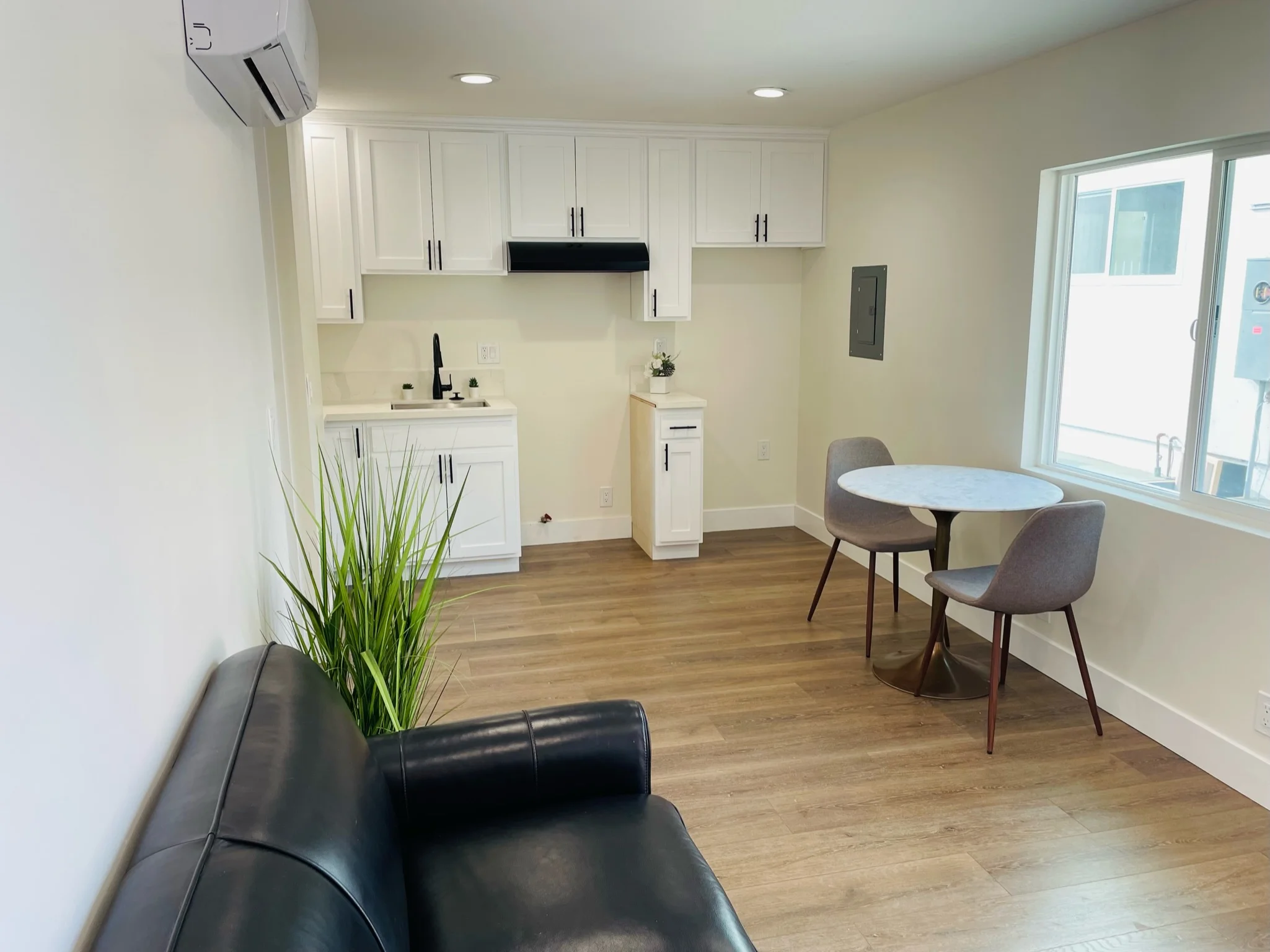 Modern office space with white cabinetry, hardwood floors, and contemporary furniture