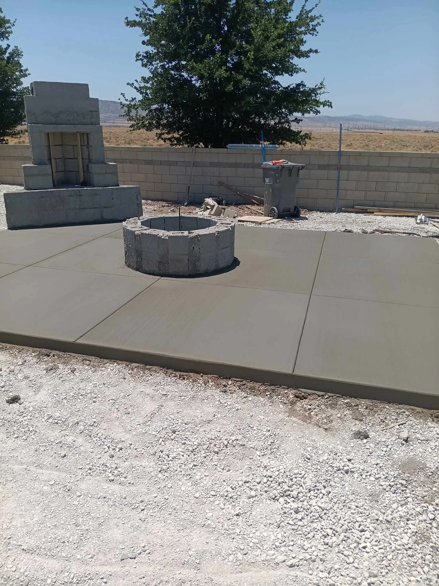Finished concrete patio with fire pit and retaining walls in Riverside