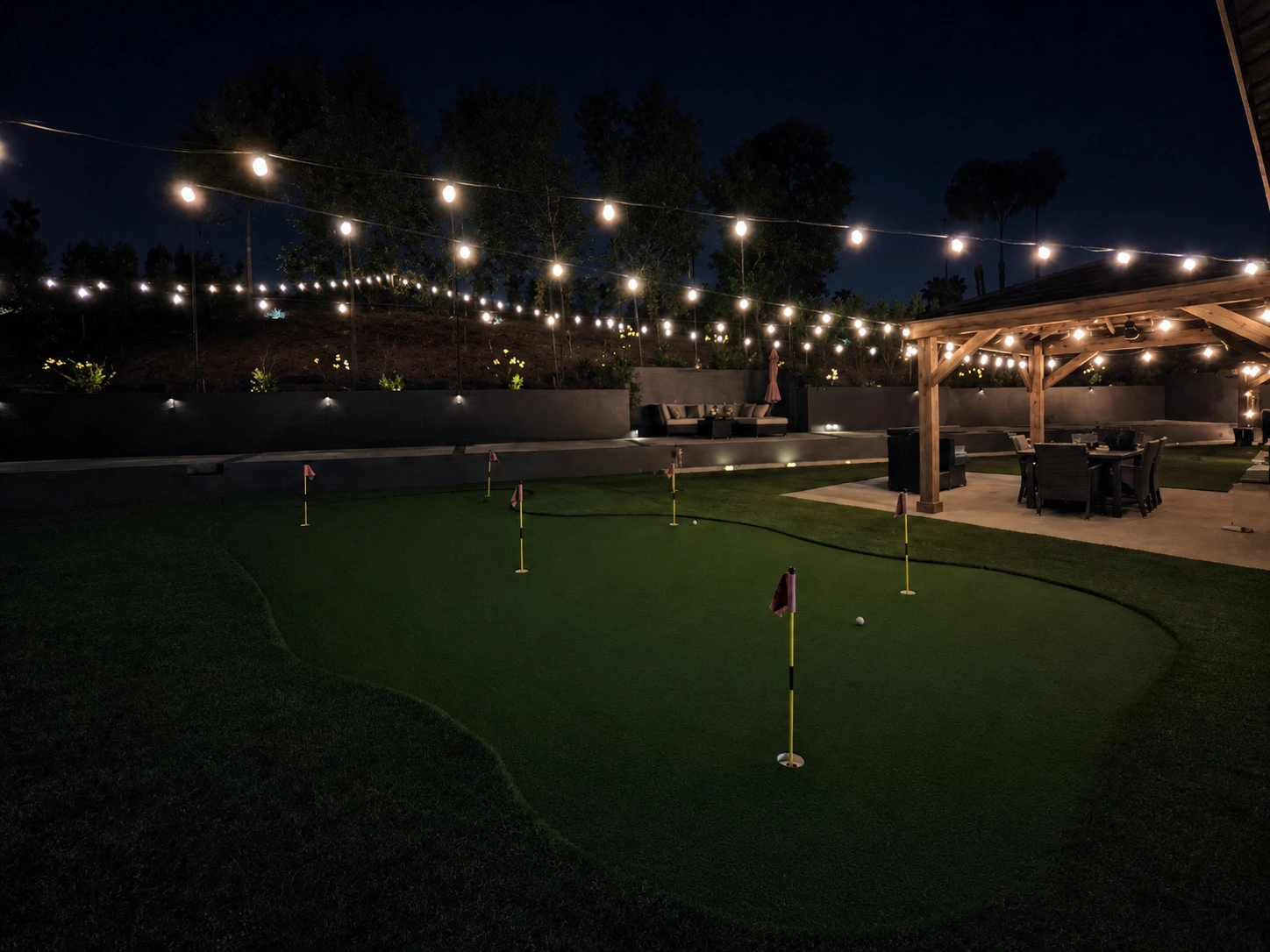 Backyard putting green with string lighting and pavilion built by Rehab Building Co. INC