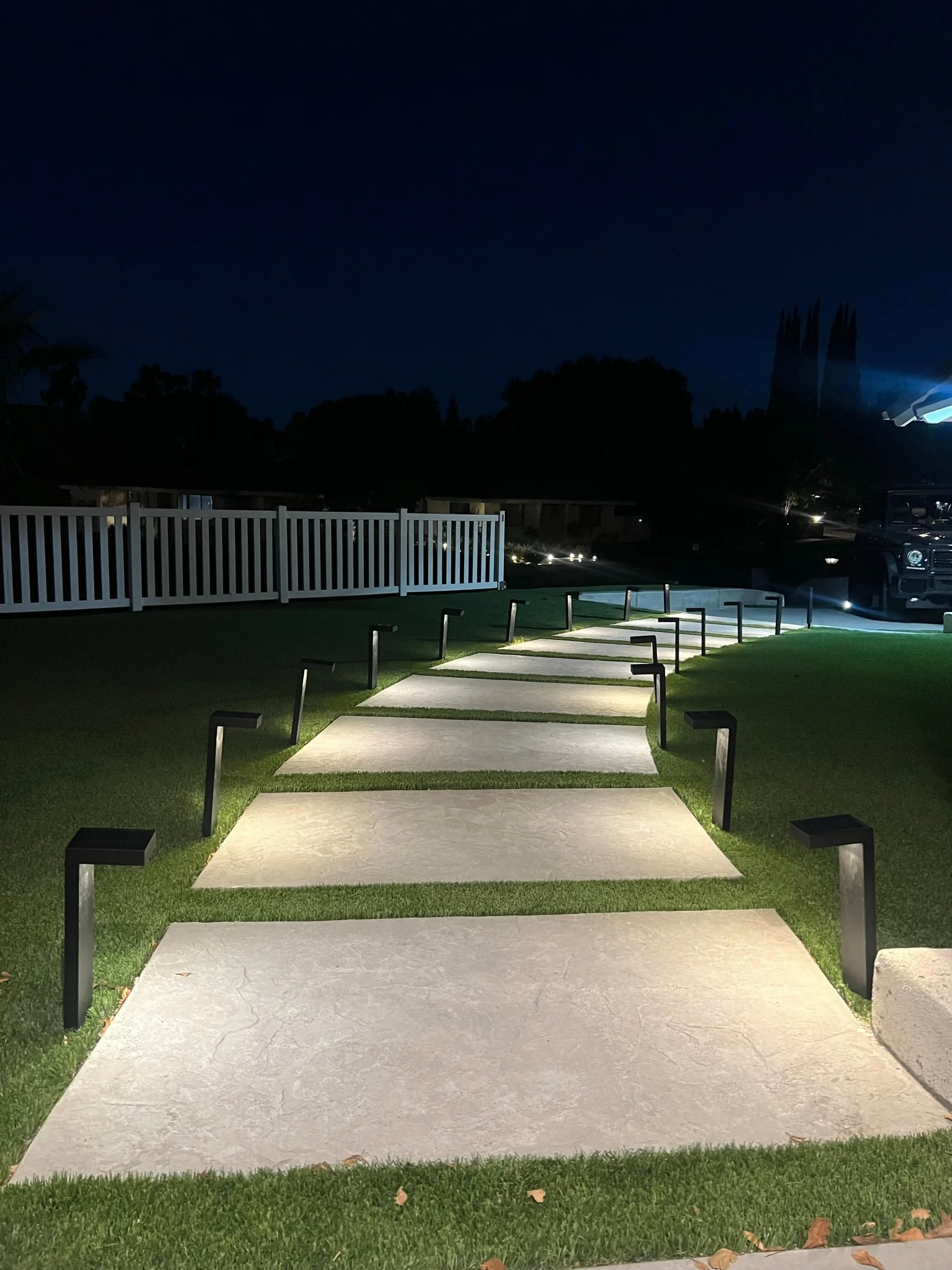 A newly installed concrete patio in a Palmdale backyard with a clean surface finish and defined edges, surrounded by desert-adapted landscaping under a clear Antelope Valley sky. The patio extends from the rear of a single-family home with open space for outdoor seating.